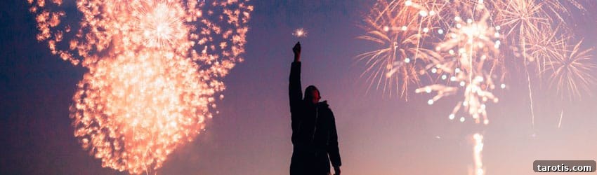 Key Astrological Transits to Watch in the Second Half of 2022 2 A celebrating person holds up sparklers in the sky where there are fireworks behind them.