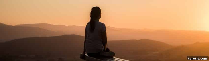 10 Essential Elements to Include in Your Monthly Full Moon Ritual 3 A person sits and reflects while watching an orange sunset.