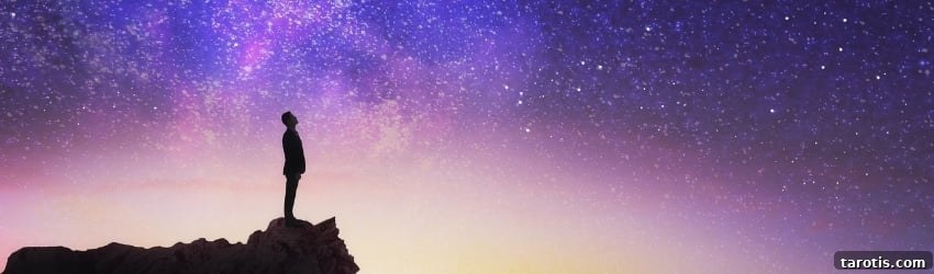 Weekly Astrology Forecast: August 23–29, 2021 — What to Expect 2 A silhouetted figure stands on a rock against the night sky, which is filled with blue, purple, and yellow hues. The white stars speckle the expansive sky.