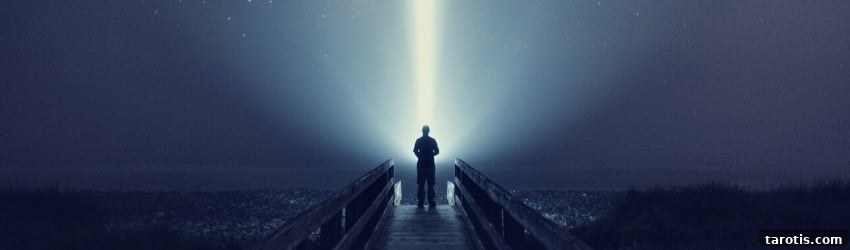 A figure stands against the night sky illuminated by a single strand of light. 