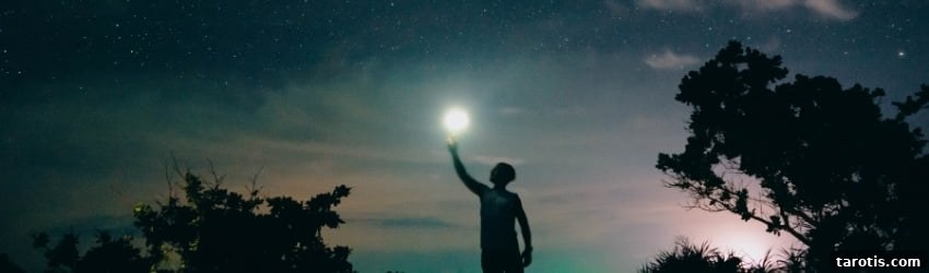 Weekly Astrology Forecast: April 26–May 2, 2021 2 A man holds a flashlight up to the sky.