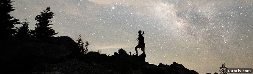 Weekly Astrology Forecast: April 12–18, 2021 — What’s Ahead for Your Sign 2 A person is climbing a hill in front of a grey colored starry sky.