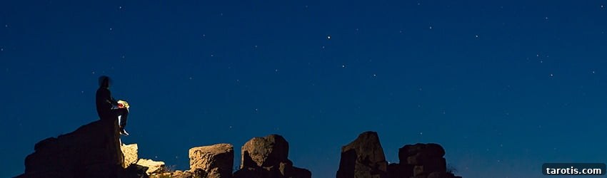 Weekly Astrology Forecast: March 15–21, 2021 2 A man sits on a rock looking up at the stars, backlit by his gas lantern.