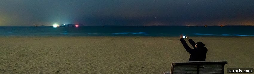 Weekly Astrology Forecast: March 1–7, 2021 — This Week's Planetary Highlights 2 A person takes a picture of the starry sky above on a beach.