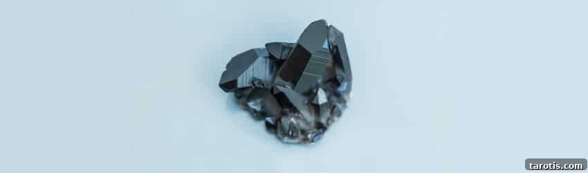 Top Crystals to Embrace Autumn Energy 5 A black hematite crystal on a blue background.