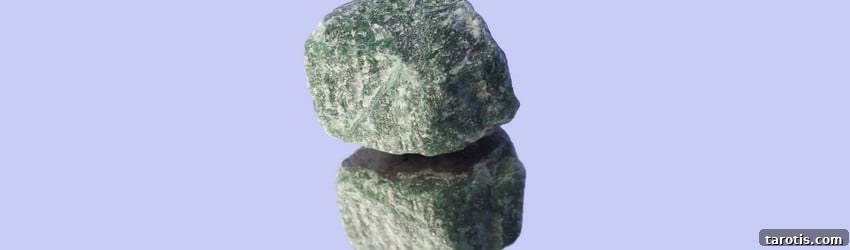 Top Crystals to Embrace Autumn Energy 8 A rough green aventurine crystal on a mirror with a purple background.