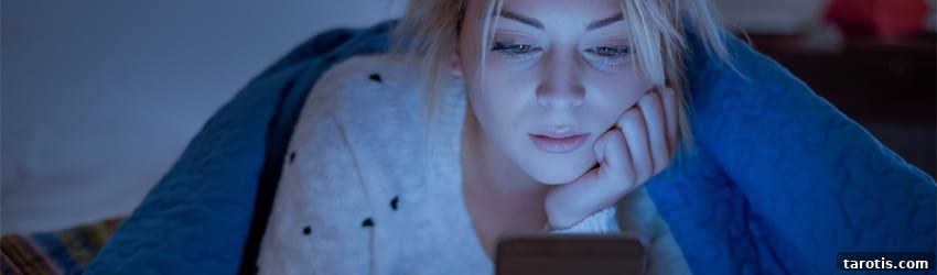 Bedtime Tarot Reading to Calm Your Mind and Sleep Better 2 A woman is texting in bed.